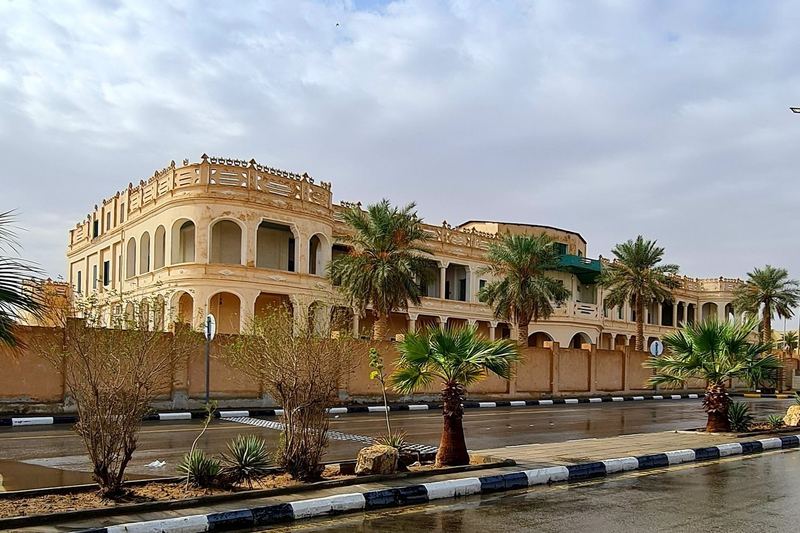 King Abdulaziz Palace in Al-Saih, an arcaded two-storey building behind palm trees
